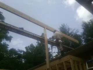 Carpenter setting a ridge beam over a new addition frame — Ice Dam Removal by Roofing Brothers in Blounts Creek