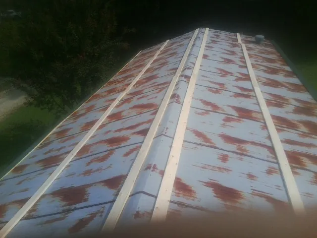Rusted metal roof panels with new wood purlins before replacement — Storm Damage Roof Repair in Blounts Creek by Roofing Brothers