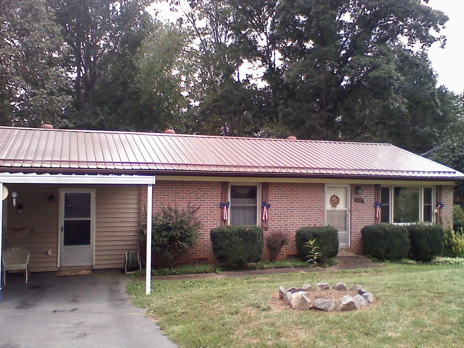 Bronze metal roof and carport on a brick ranch home — Roof Repair work by our crew in Blounts Creek